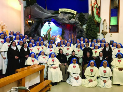 Group of nuns Apostles of Infinite Love near the Christmas Crib, Gruppe von Nonnen Apostel der Unendlichen Liebe in der Nähe der Weihnachtskrippe.