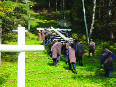 Les Frères portent la Croix vers le haut de la montagne.