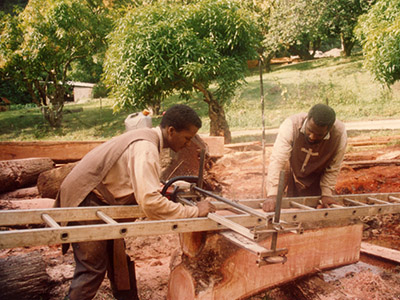 Fabrication de poutres de mahogany chez les Apôtres de l'Amour Infini